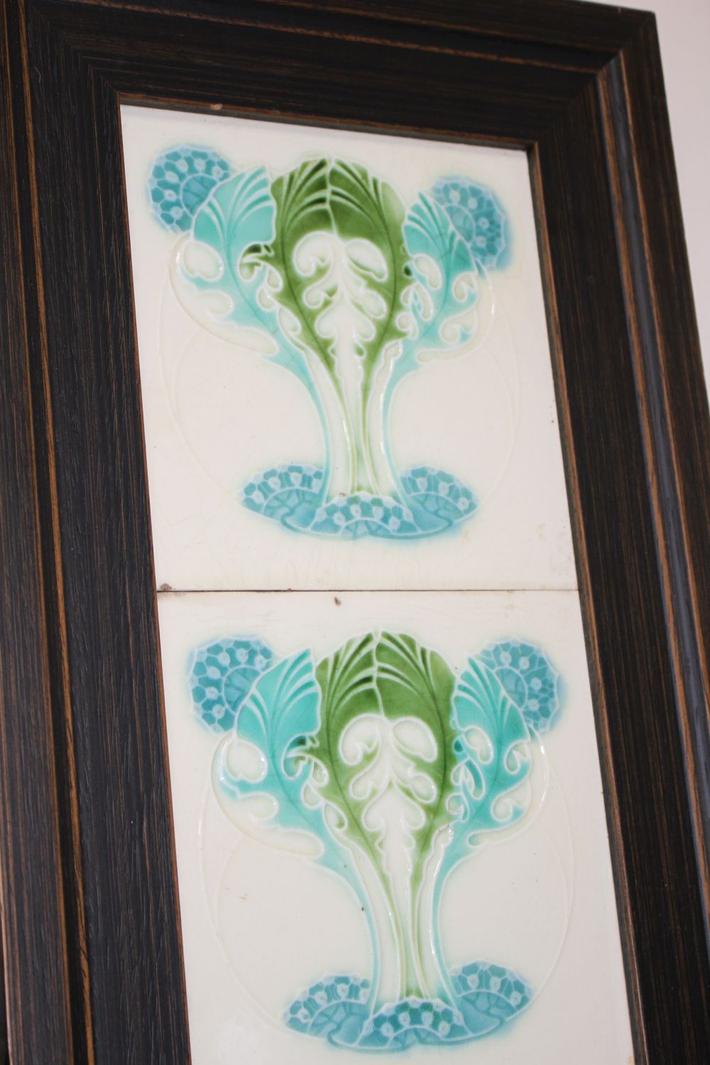 A pair of Victorian apple blossom tile panels and a set of six Art Nouveau foliate design tiles, all framed